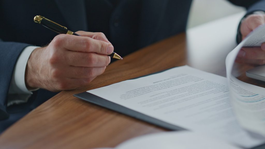 abogado revisando documentación empresarial contratos en despacho