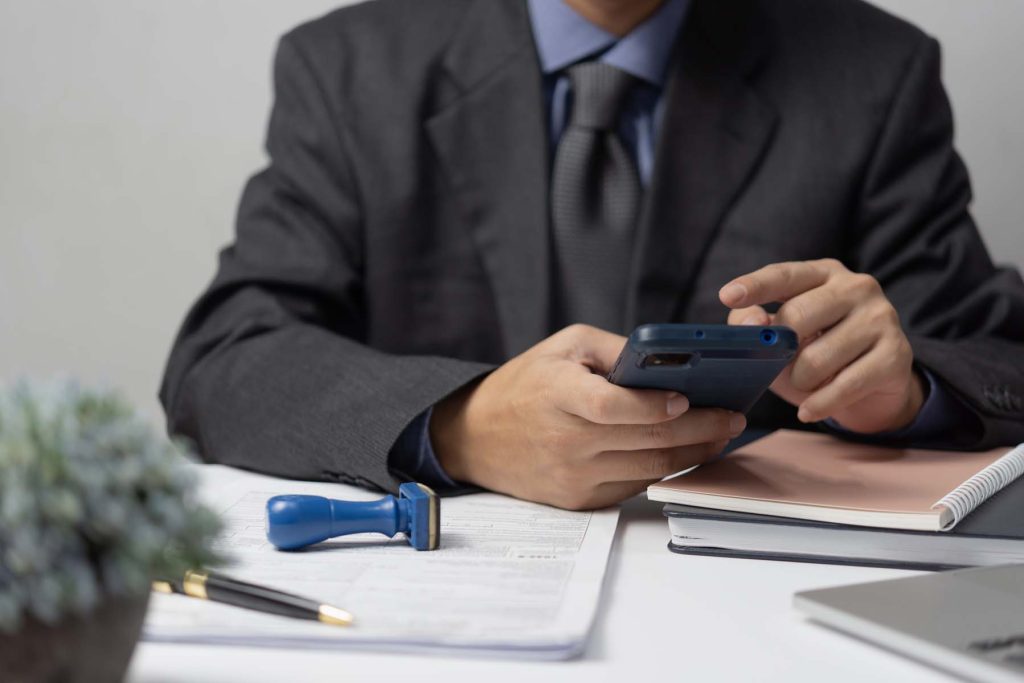 abogado utilizando móvil de empresa en despacho personal