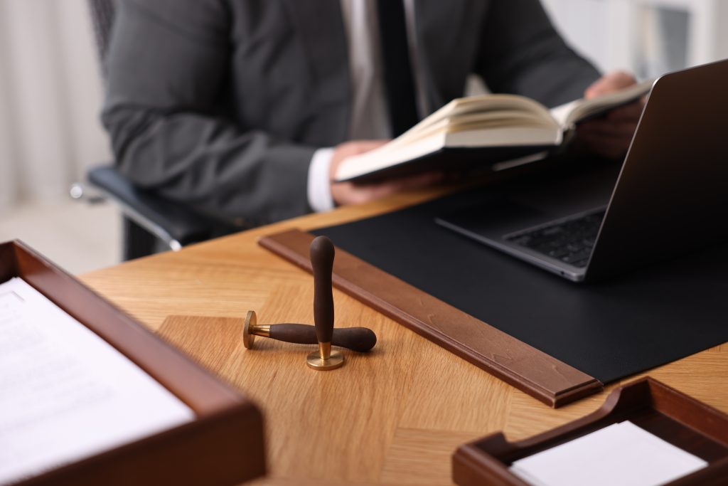 abogado revisando los documentos del libro y portatil